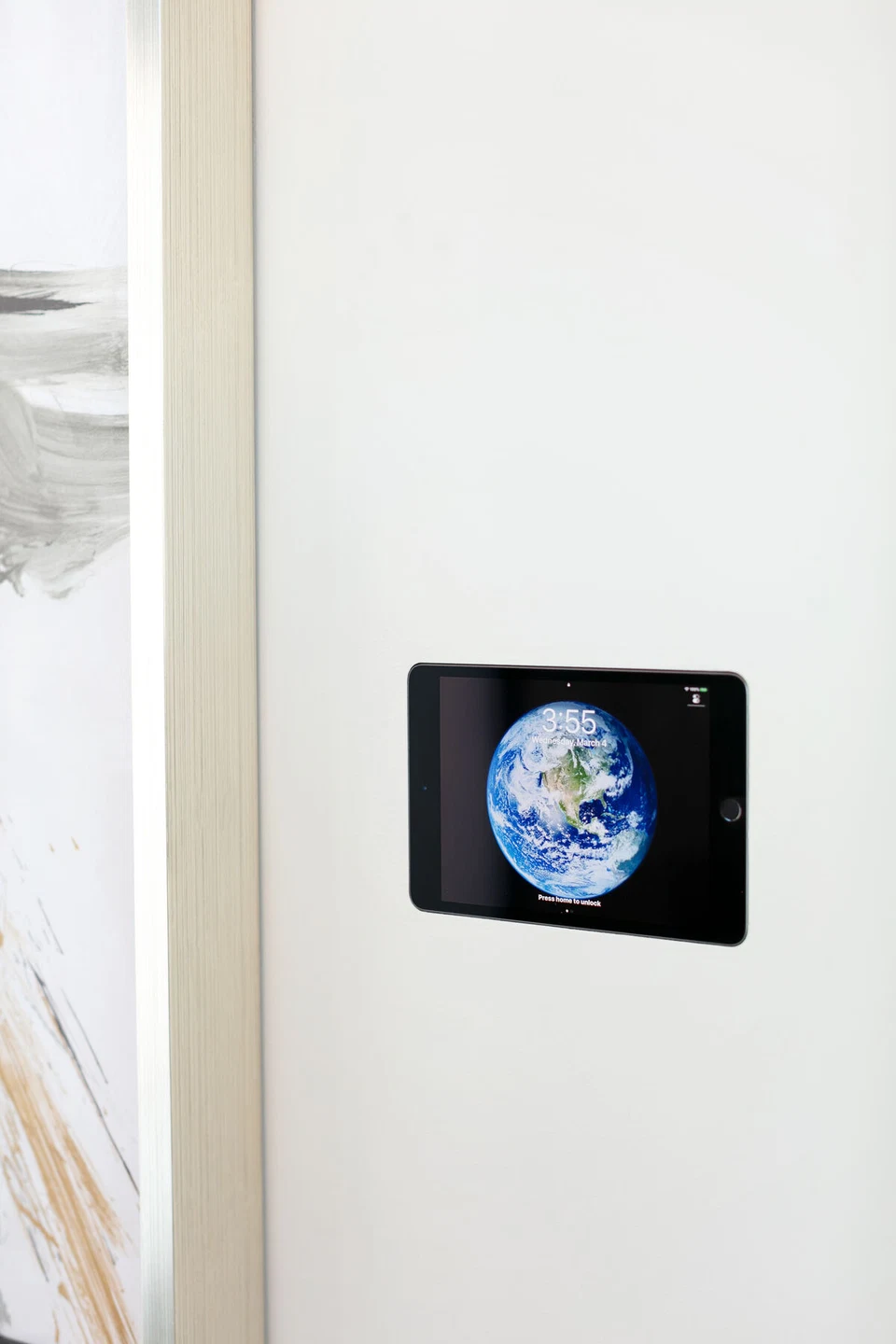 Black wall-mounted touchscreen displaying a clock