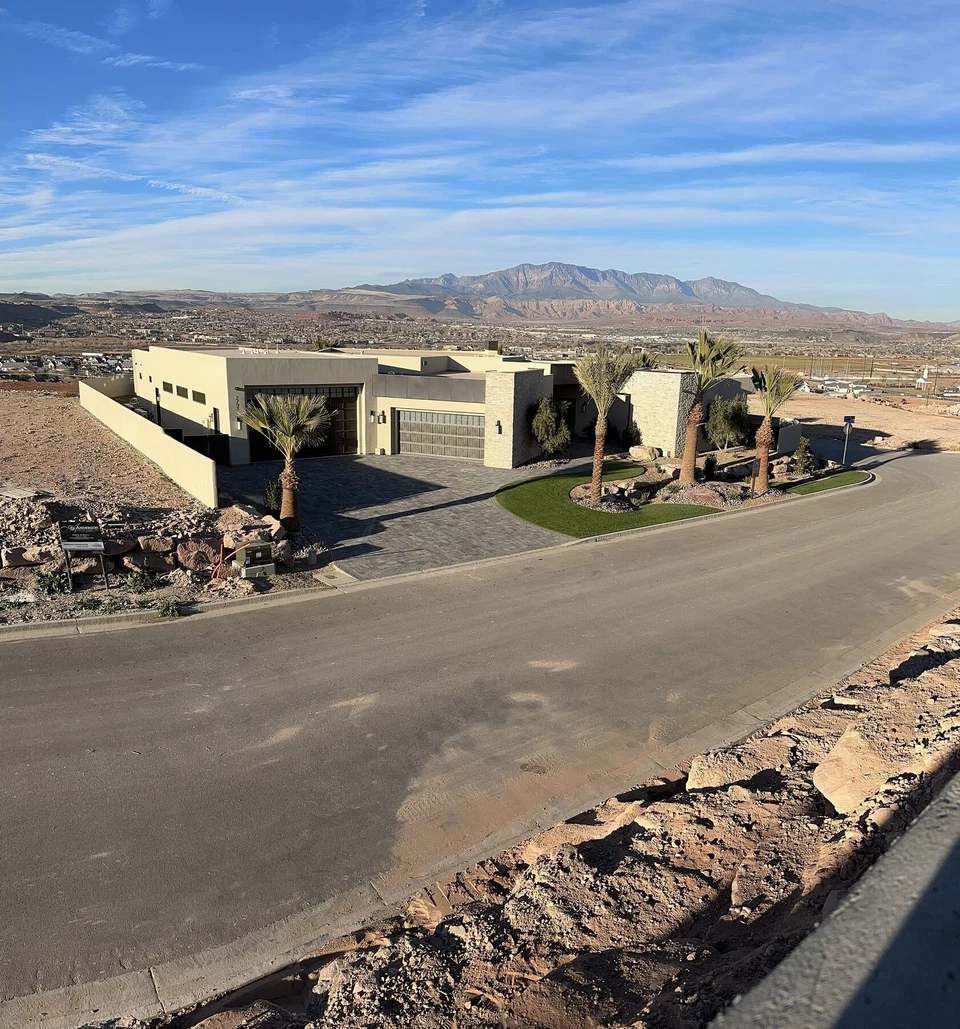 Wide view of the single-story home and surrounding desert terrain