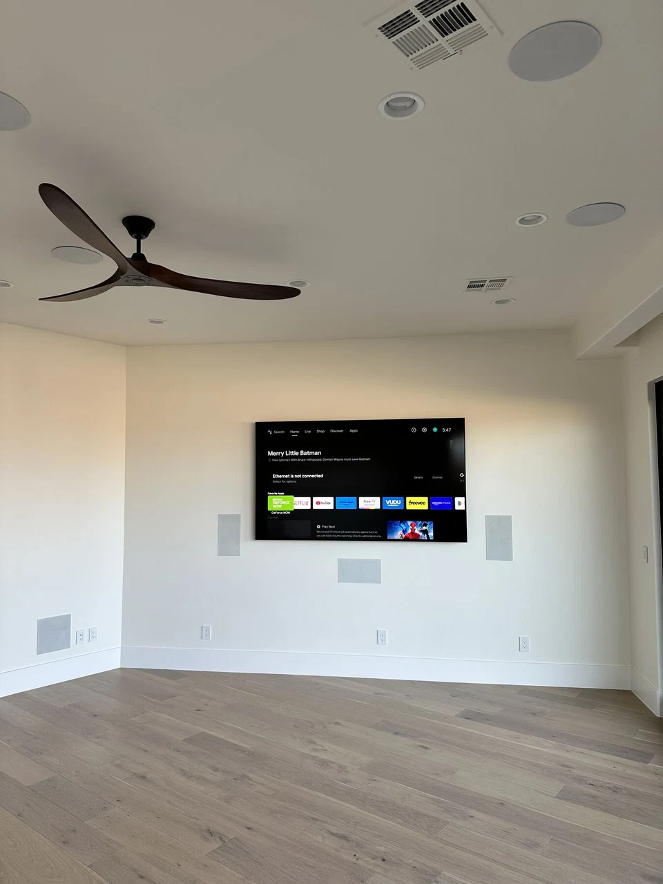 Unfurnished media room with television, ceiling speakers, and ceiling fan
