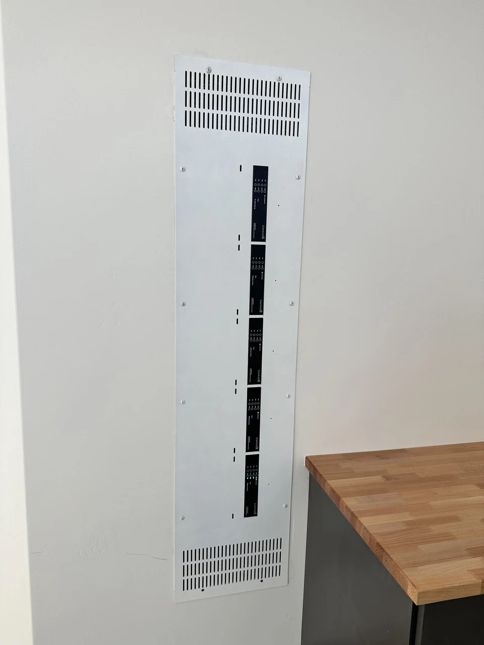 Tall recessed equipment panel with vertical ventilation slots
