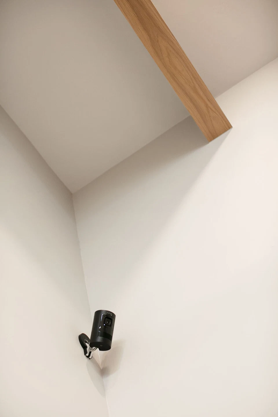 Small black wall-mounted speaker beneath a ceiling beam