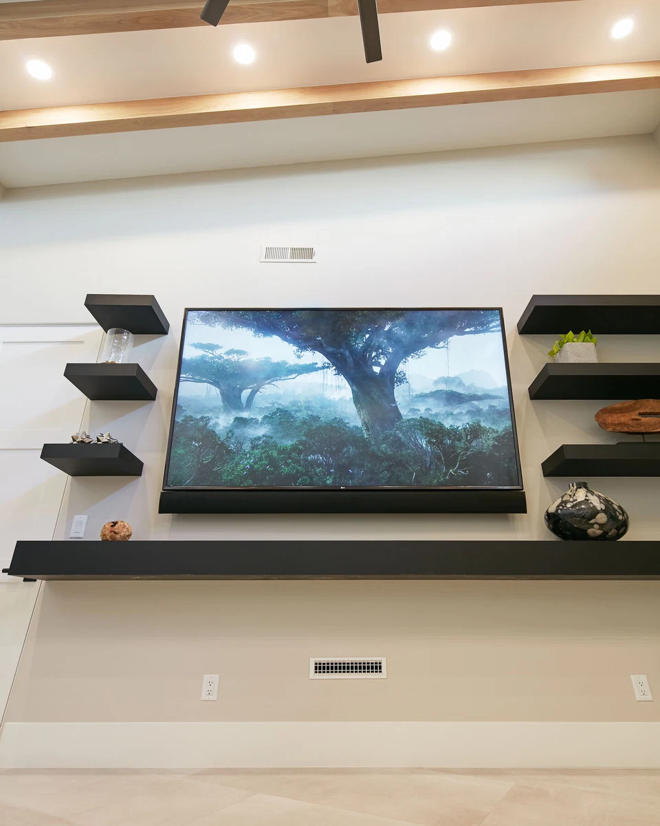 Television and soundbar beneath exposed wood ceiling beams