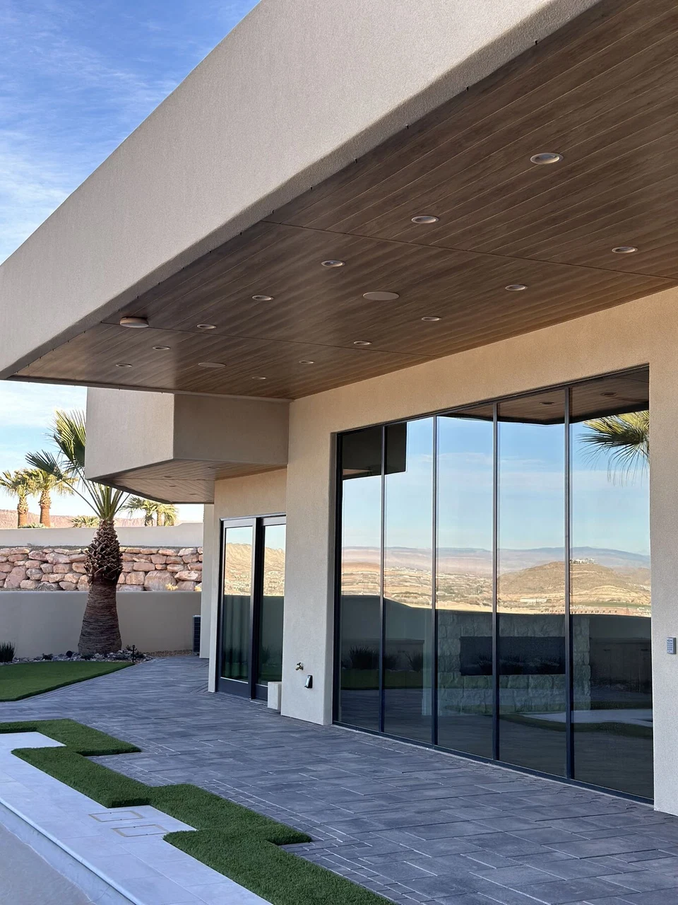 Covered patio with recessed wood-ceiling lights and sliding glass doors
