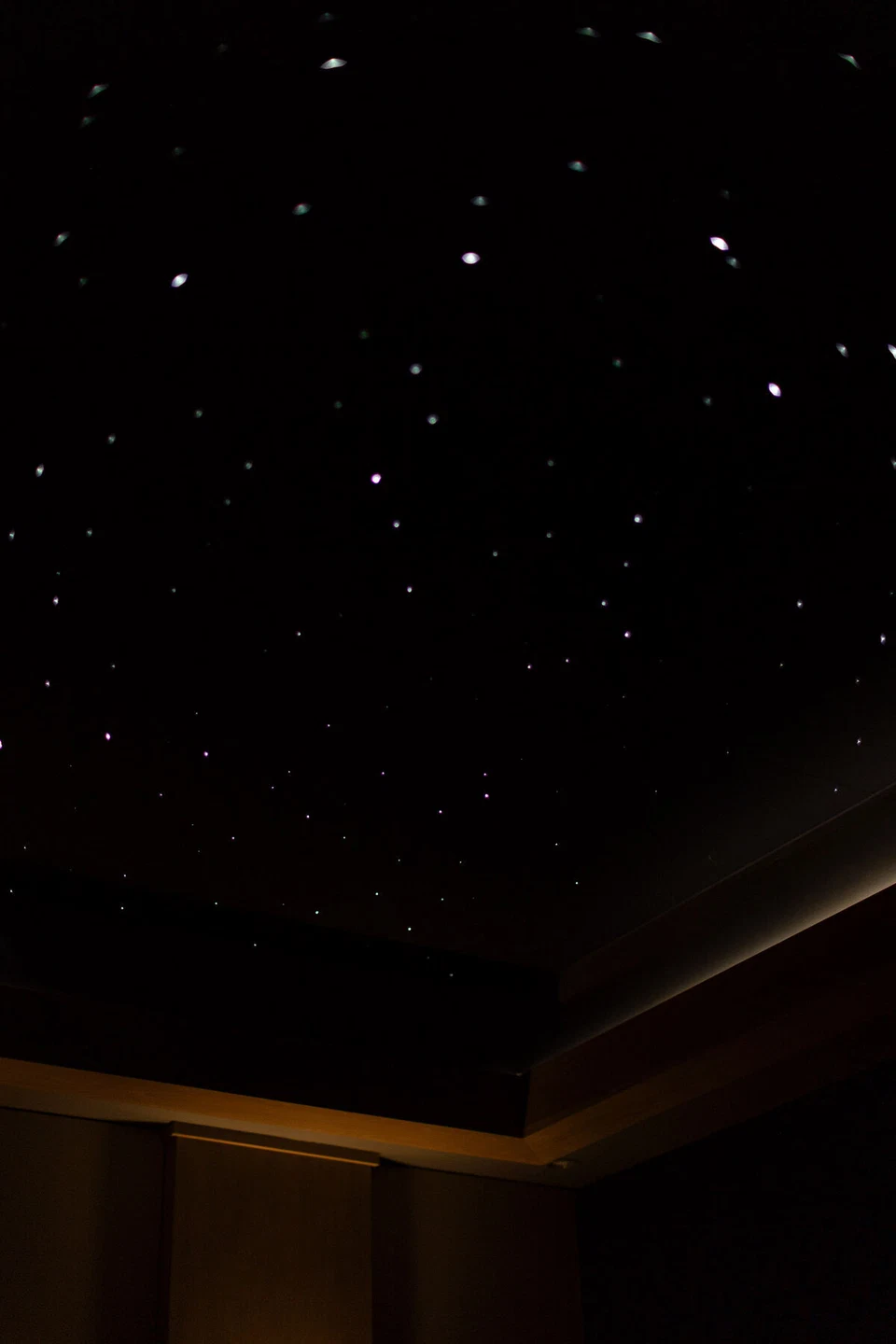 Fiber-optic star lights across a dark home theater ceiling
