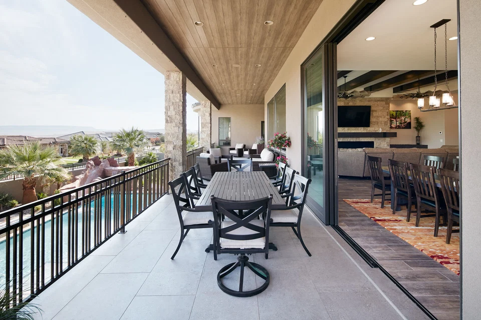 Covered balcony dining area beside open doors to the kitchen