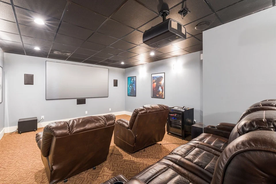 Private home cinema with leather recliners, projection screen, and surround speakers