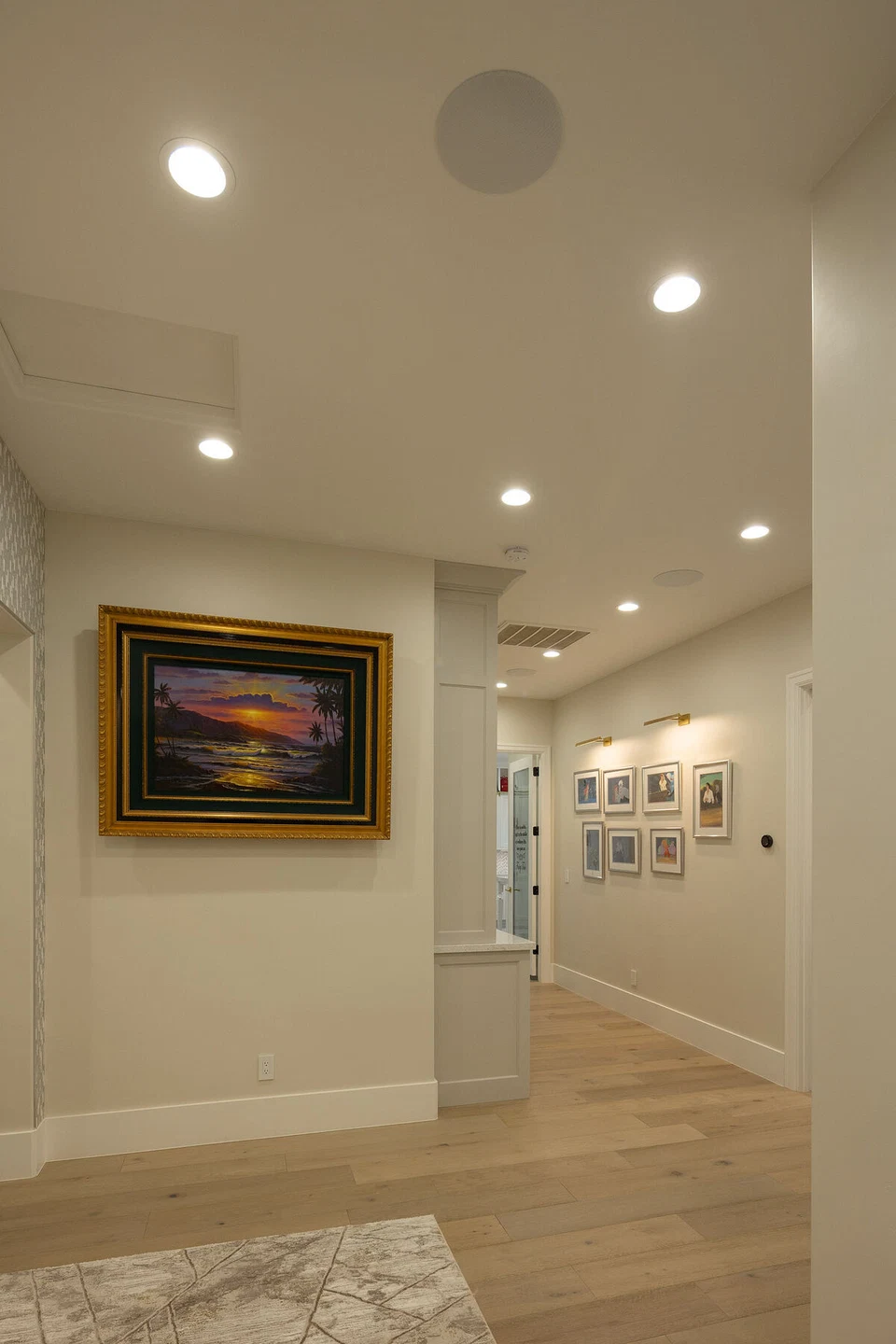 Hallway with recessed ceiling lights and framed artwork
