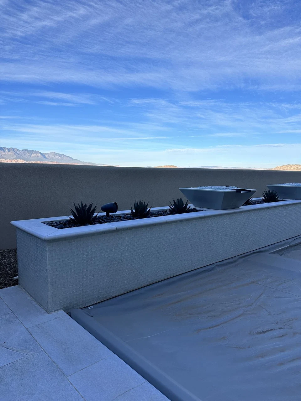 Patio paving and raised planting bed against a desert mountain backdrop