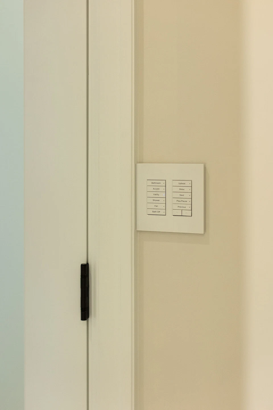 White lighting controls beside a bathroom doorway