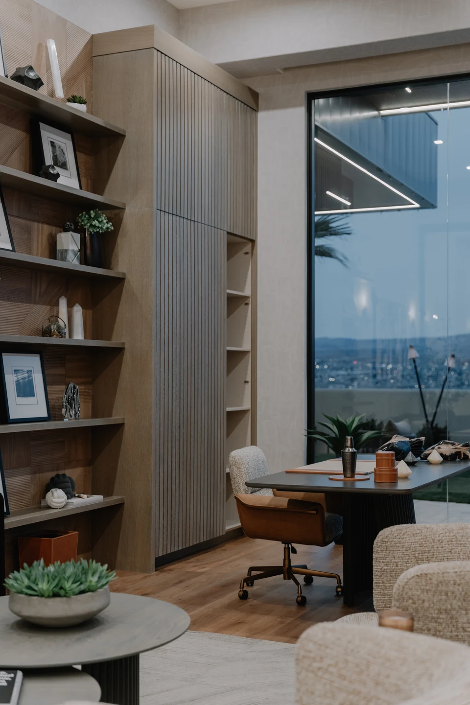 Reading nook with curved shelving, an armchair, and a tall window