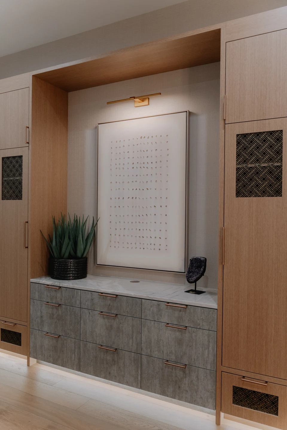 Kitchen cabinetry with an illuminated stone counter and shaded window