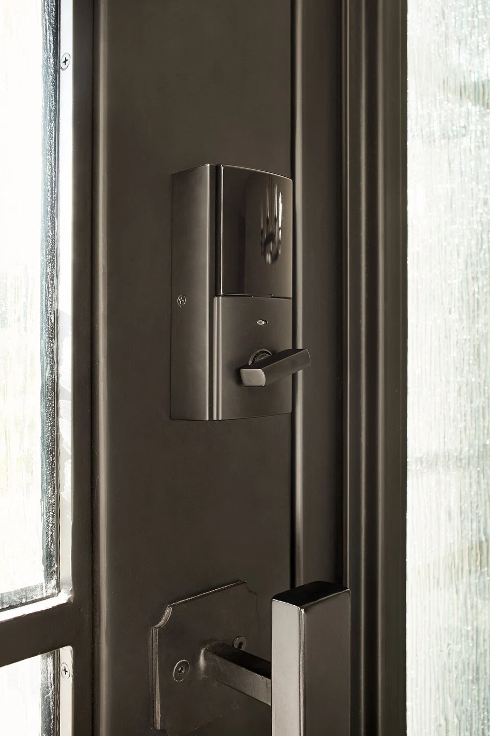 Electronic door lock on the interior of a dark entry door