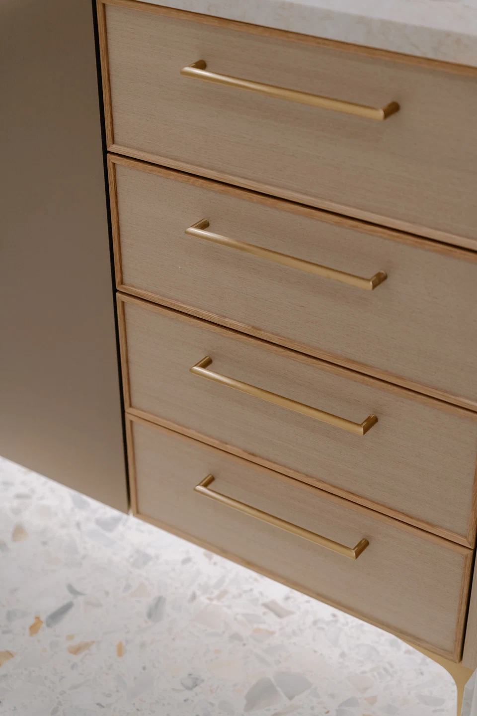 Warm under-cabinet lighting beneath bathroom drawers above a patterned rug