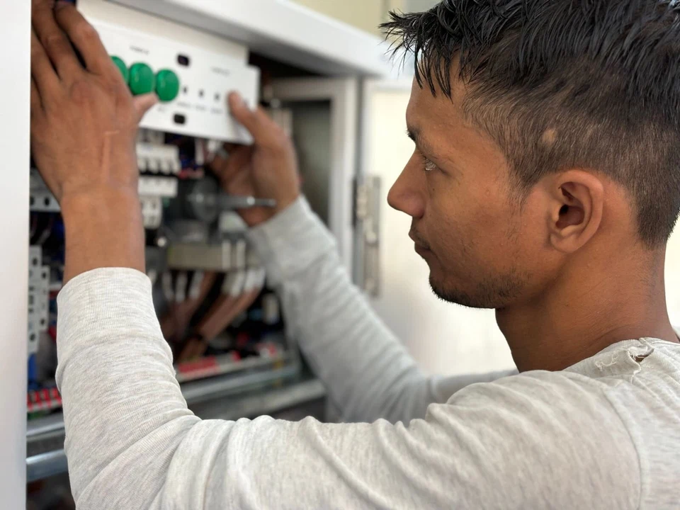 Electrician working on an electrical control panel