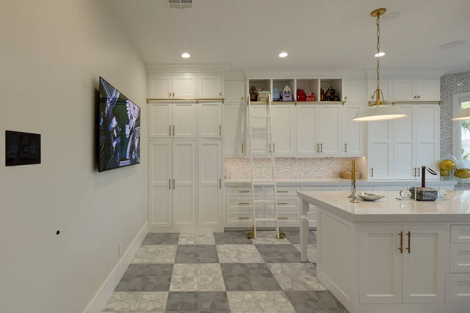 White kitchen with wall-mounted television and checkered floor tiles