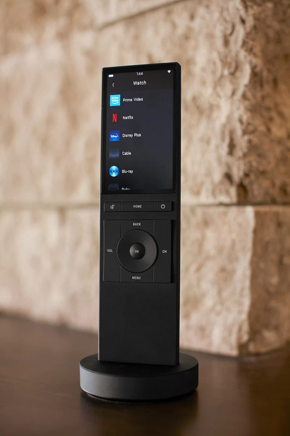 Angled close view of a black touchscreen remote on its charging base
