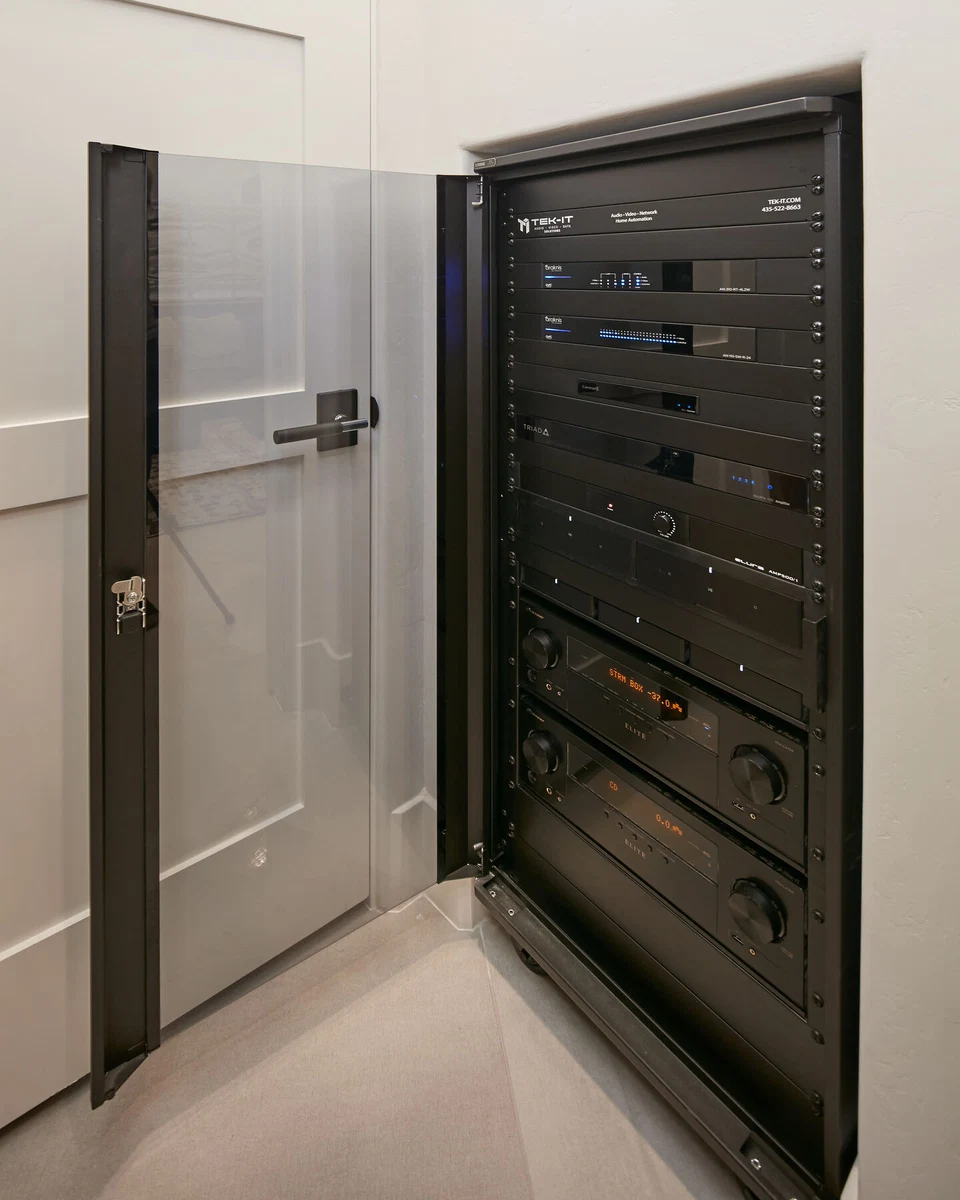 Glass-front equipment rack beside an open closet door