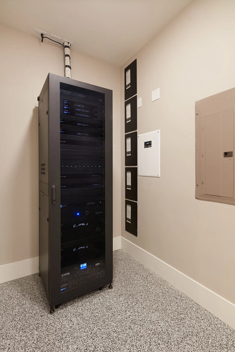 Tall black equipment rack recessed into a utility room wall
