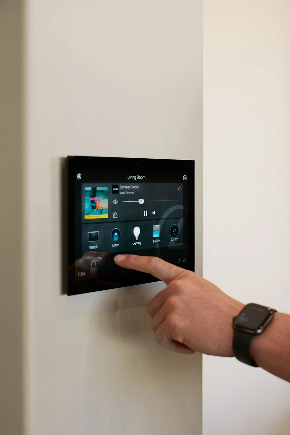 Hand selecting a control on a wall-mounted home touchscreen