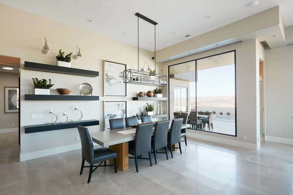 Dining table beneath a linear pendant beside the kitchen island