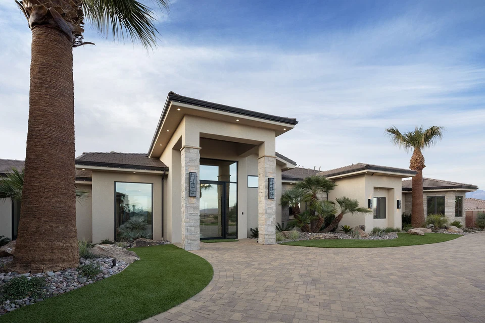 Front entrance with tall glass doors beneath a stone-clad porch