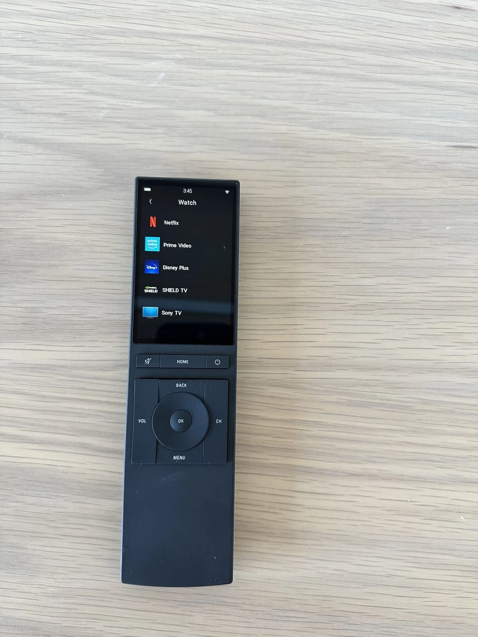 Handheld touchscreen remote with illuminated controls shown from the side