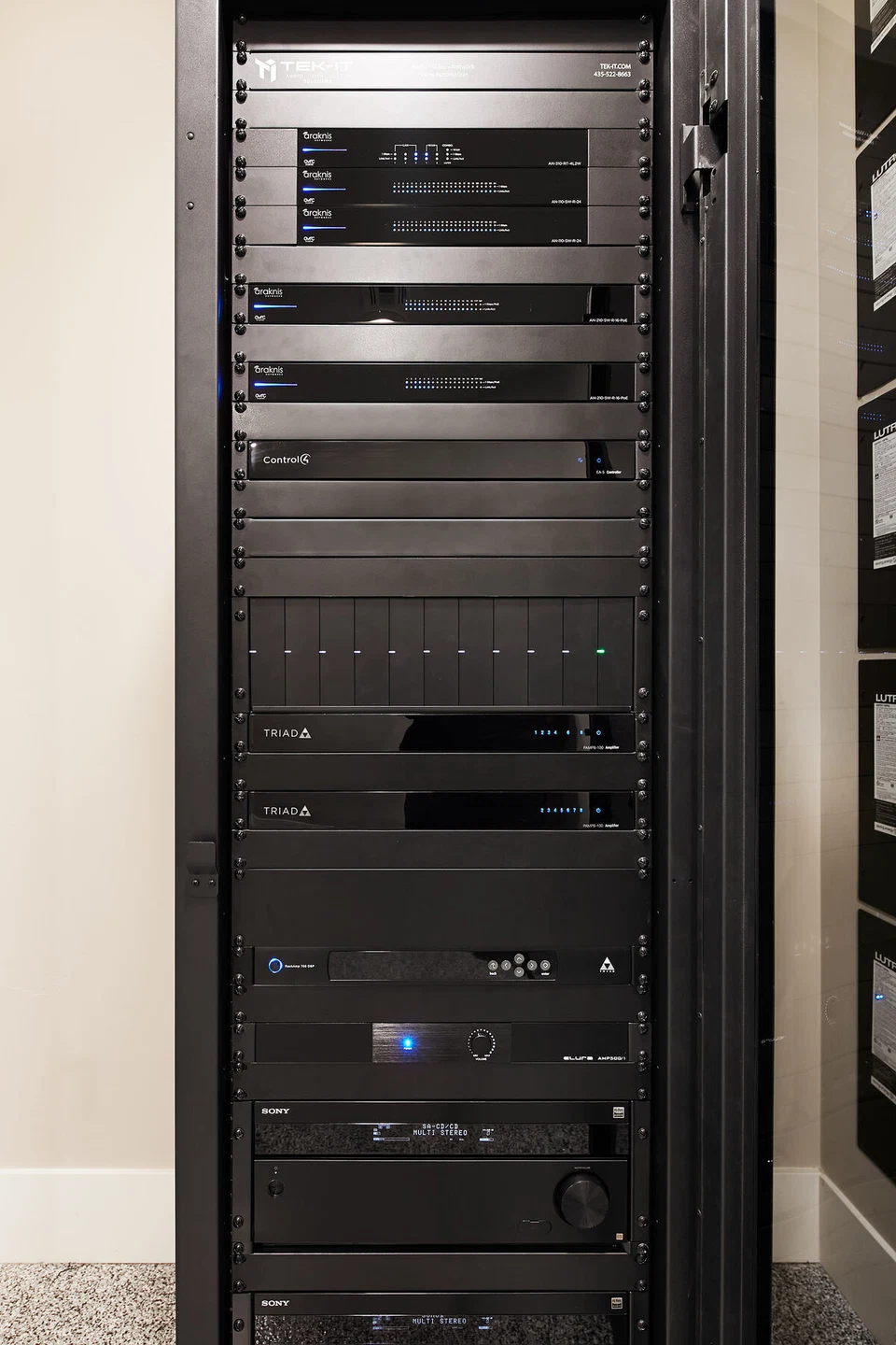 Close view of stacked AV components behind an equipment rack door