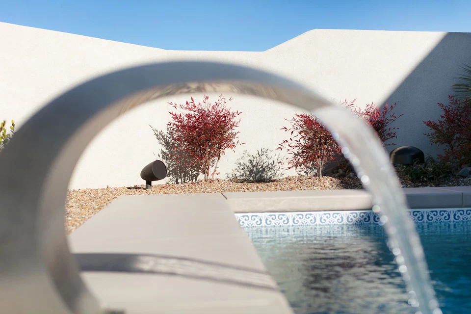 Close view of a pool fountain arch and flowing water