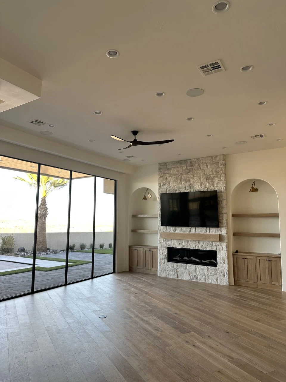 Unfurnished living room with fireplace, ceiling fan, and sliding patio doors
