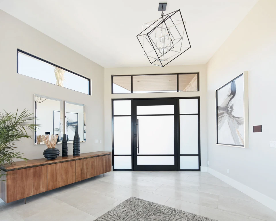 Bright entry hall with glass front doors and geometric pendant light