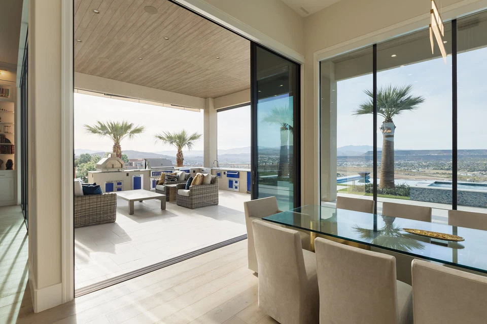 Open sliding doors connecting the dining room to covered outdoor seating