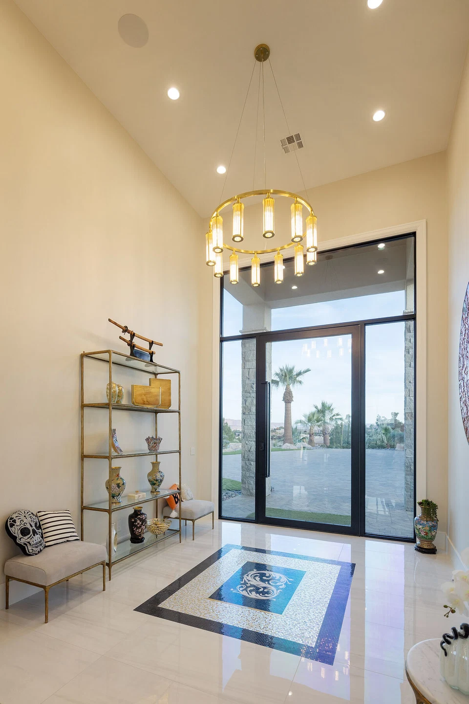 Entry hall chandelier and recessed lighting above glass front doors