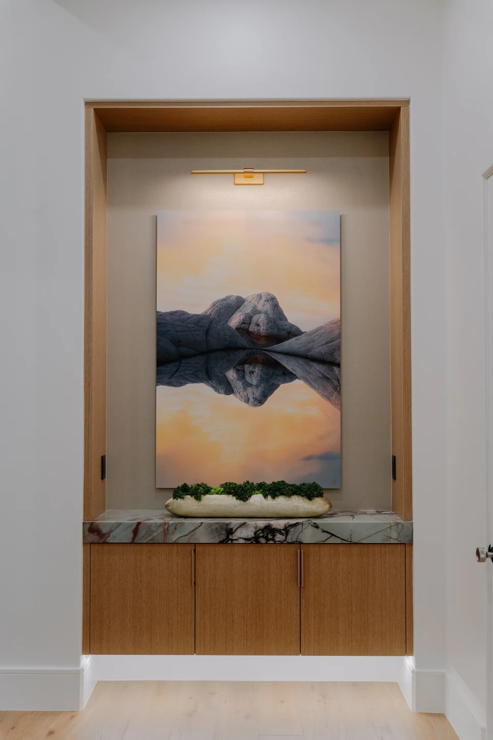 Recessed display niche with artwork, decorative objects, and accent lighting
