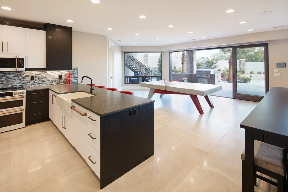 Lower-level kitchen opening to a recreation area with a red pool table