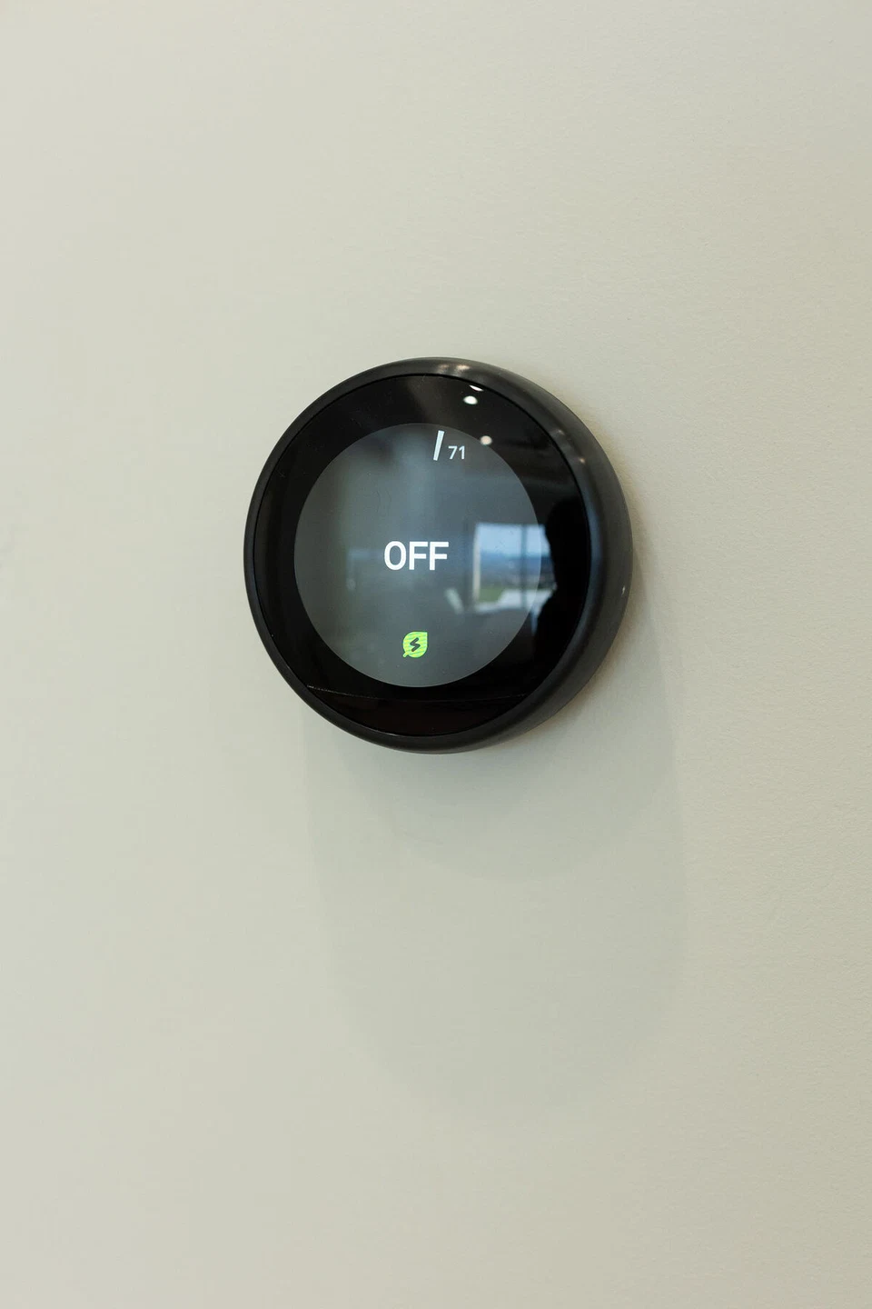 Round black thermostat displaying its off setting