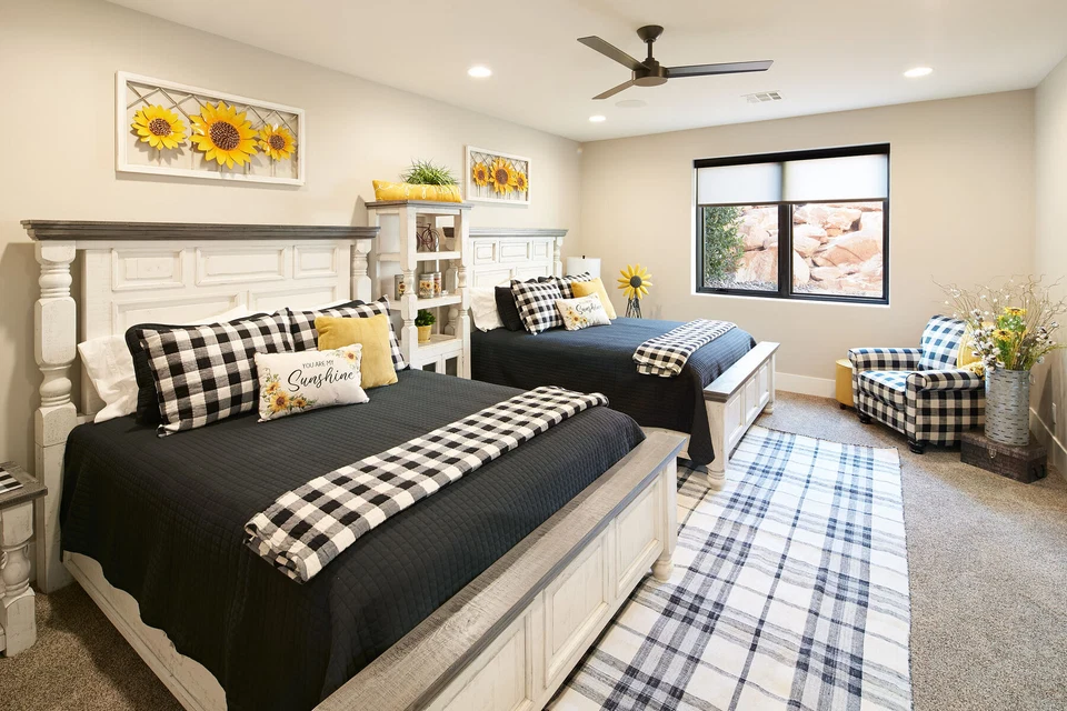 Guest bedroom with twin beds, plaid bedding, and a ceiling fan