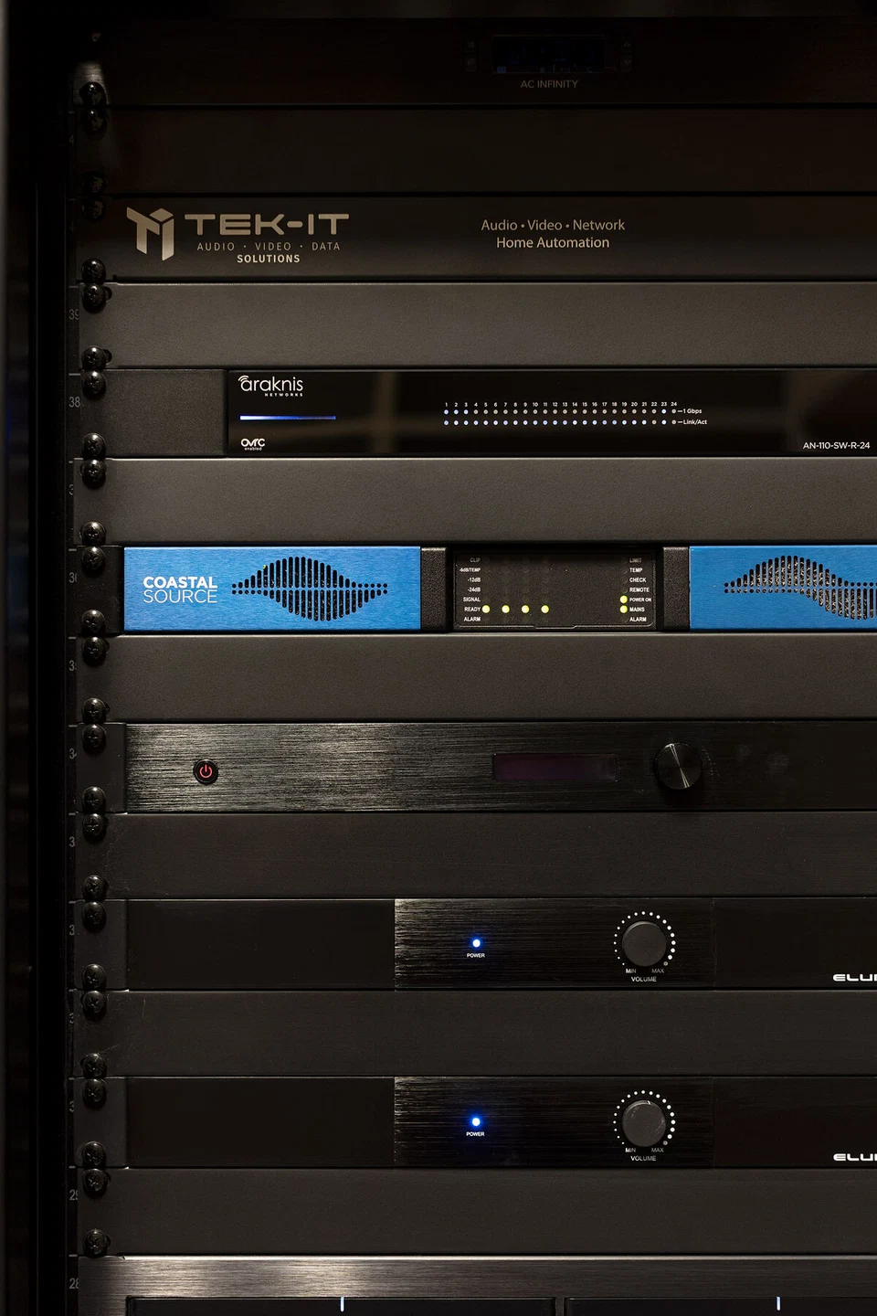 Close view of rack-mounted AV components with illuminated front displays