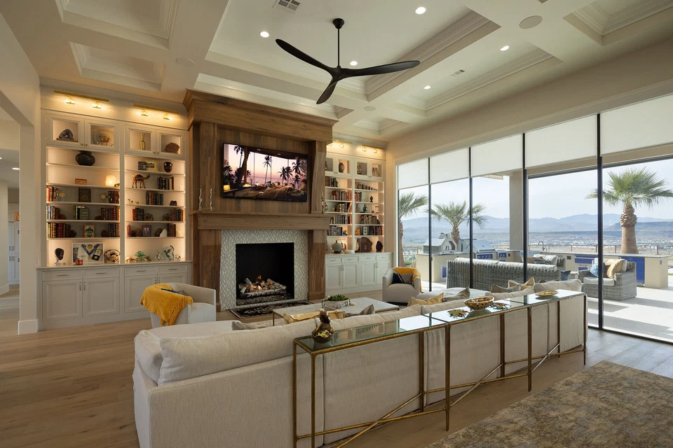 Living room with television above the fireplace and illuminated display shelves