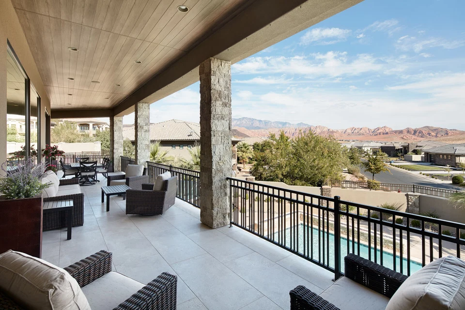 Covered balcony lounge with outdoor seating and a metal railing