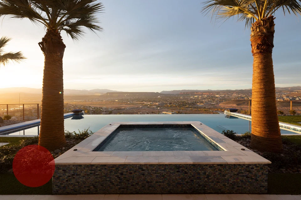 Raised square spa between palm trees overlooking the valley at sunset