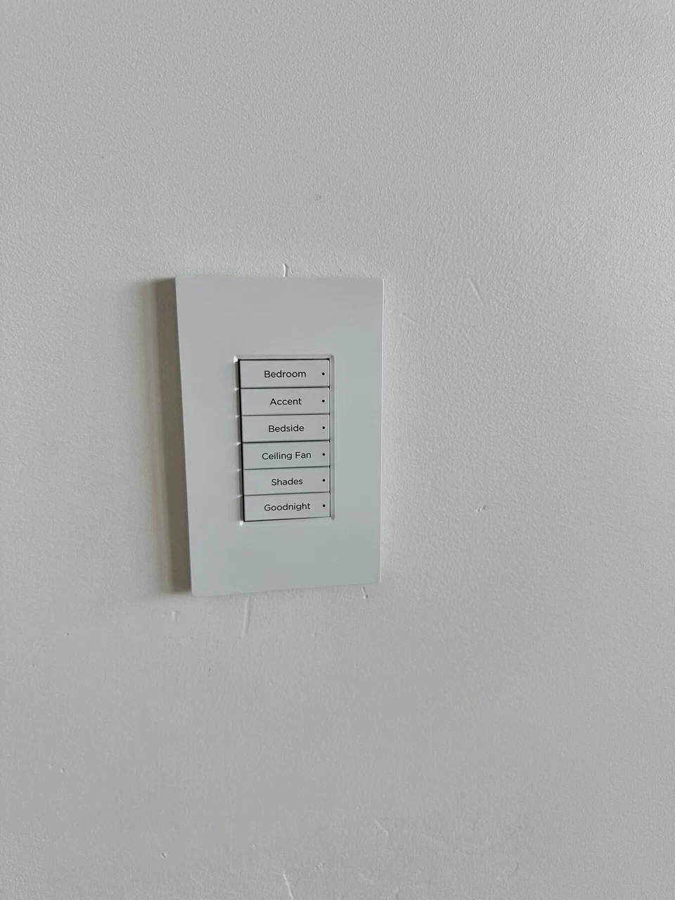 White multi-button lighting keypad on a pale wall