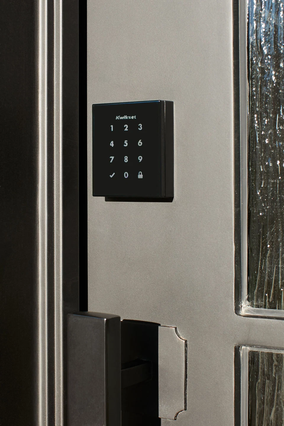 Black wall keypad beside the glass entry door