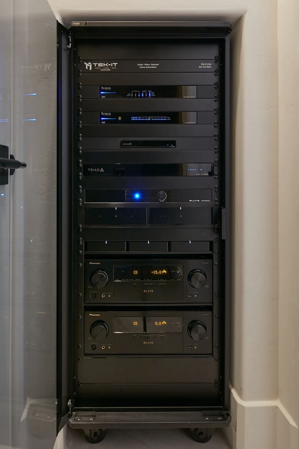 Front view of stacked AV components inside a tall equipment rack