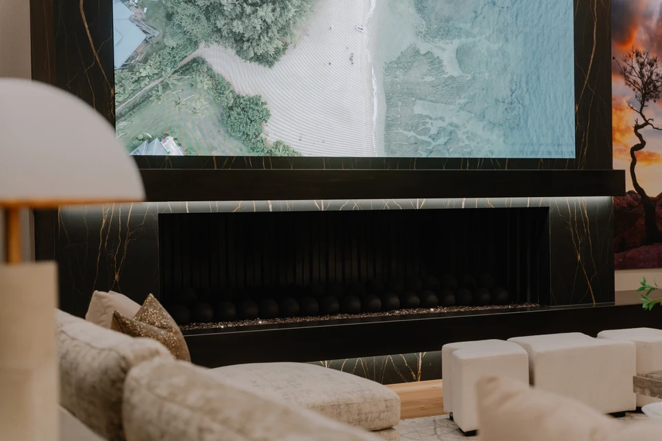 Large living room screen above a dark fireplace with sofas in front