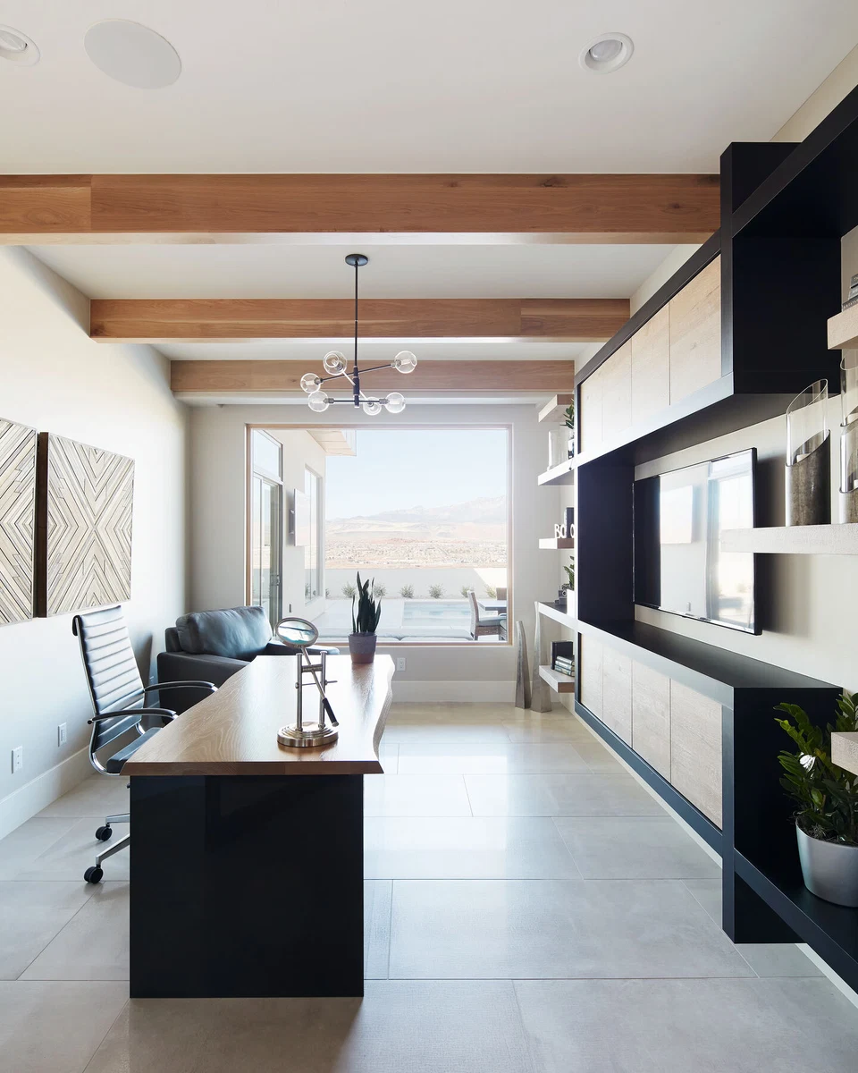 Long office and sitting area with built-in shelves and exposed ceiling beams